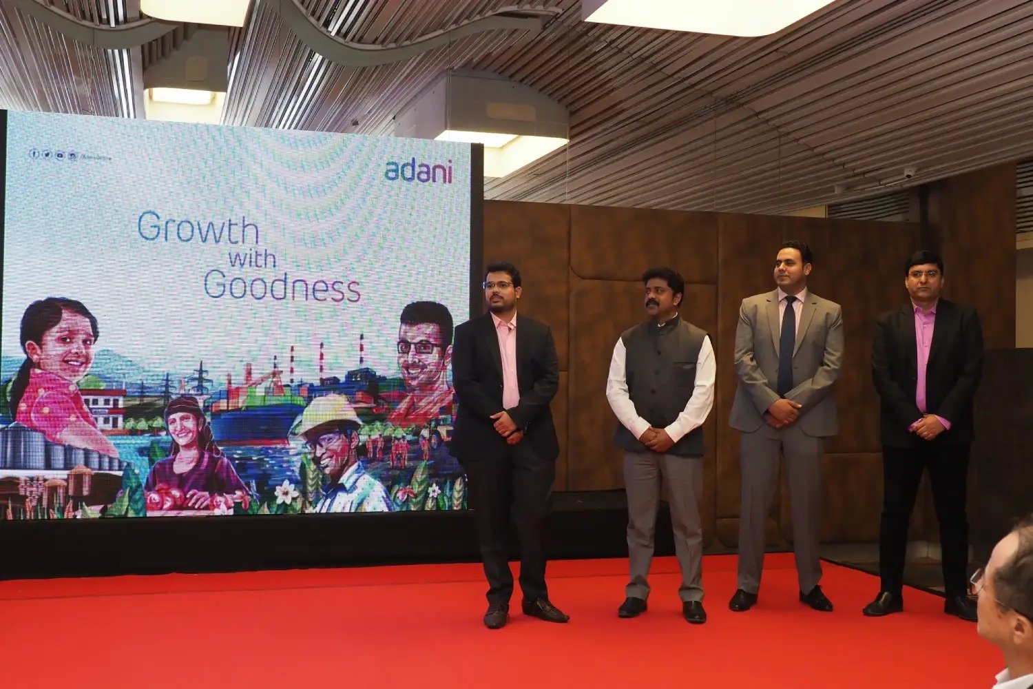 Men lighting ceremonial lamp at event with ITT banner in background