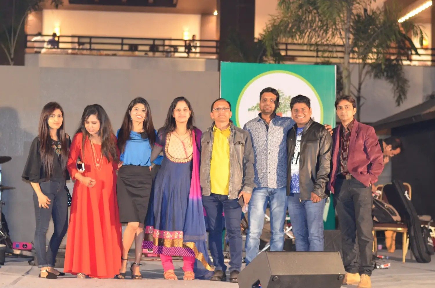 Man and woman speaking on stage at night with blue lighting