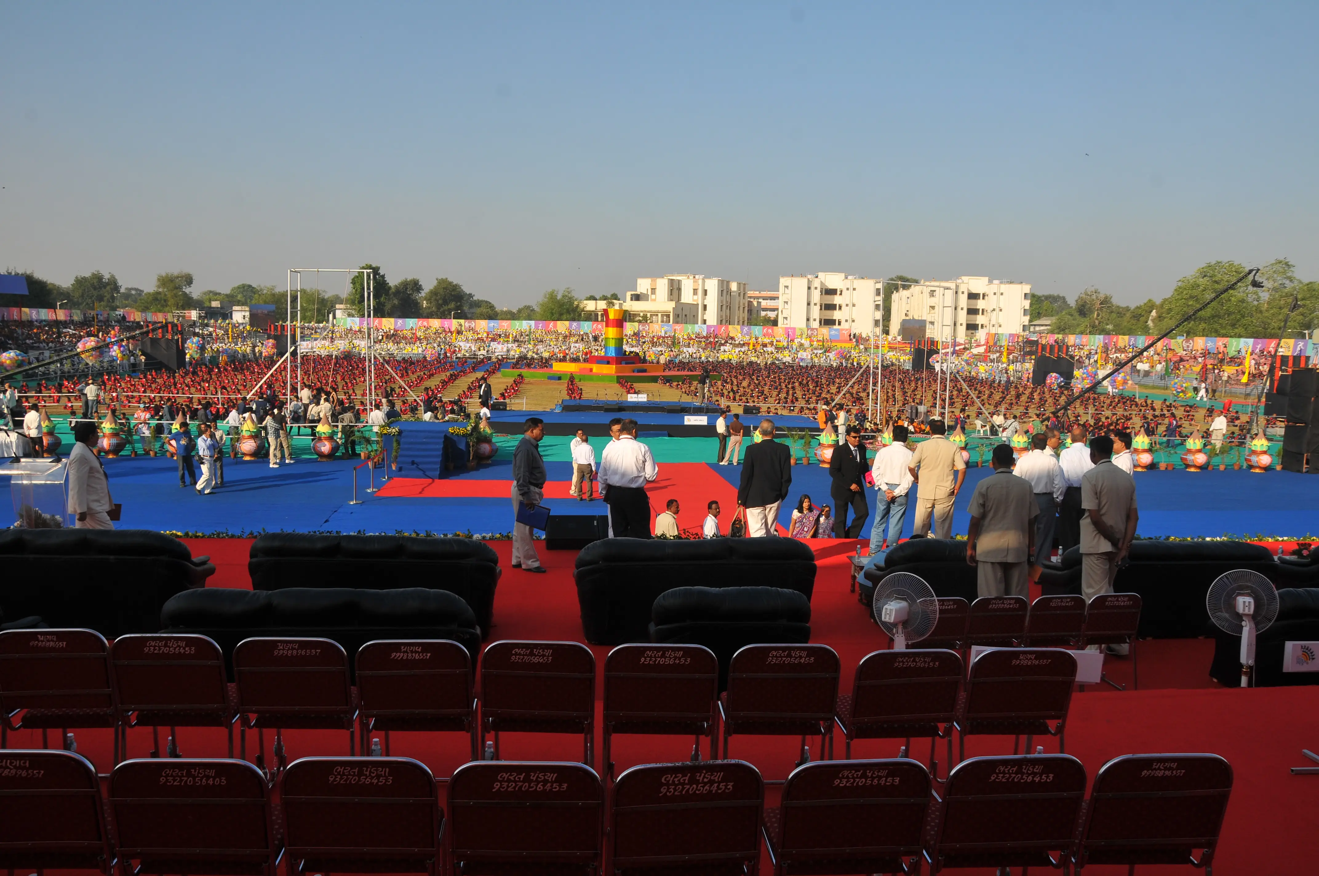 Balloon arch in orange, black, and white colors framing an ITT logo board lit with warm lights
