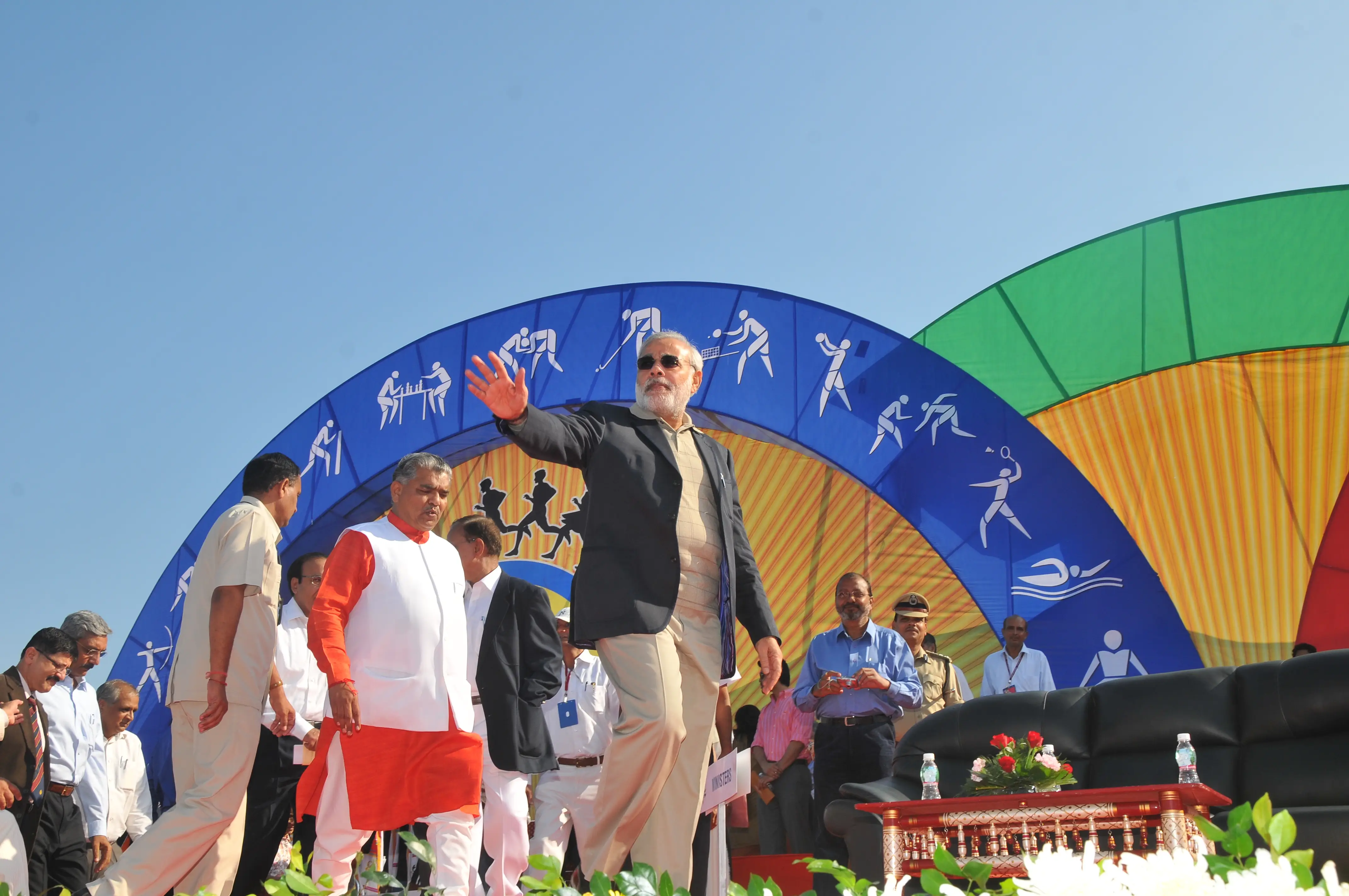 Men lighting ceremonial lamp at event with ITT banner in background