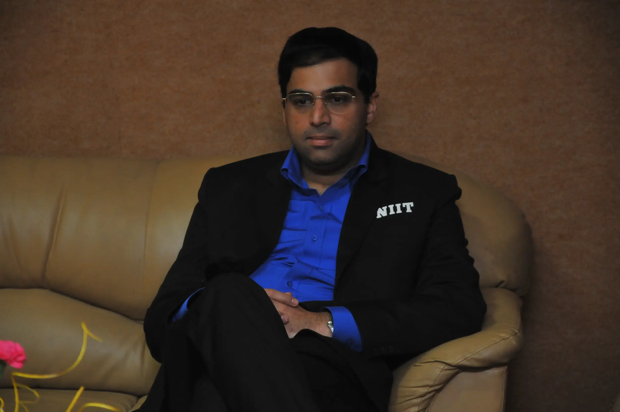 Men lighting ceremonial lamp at event with ITT banner in background