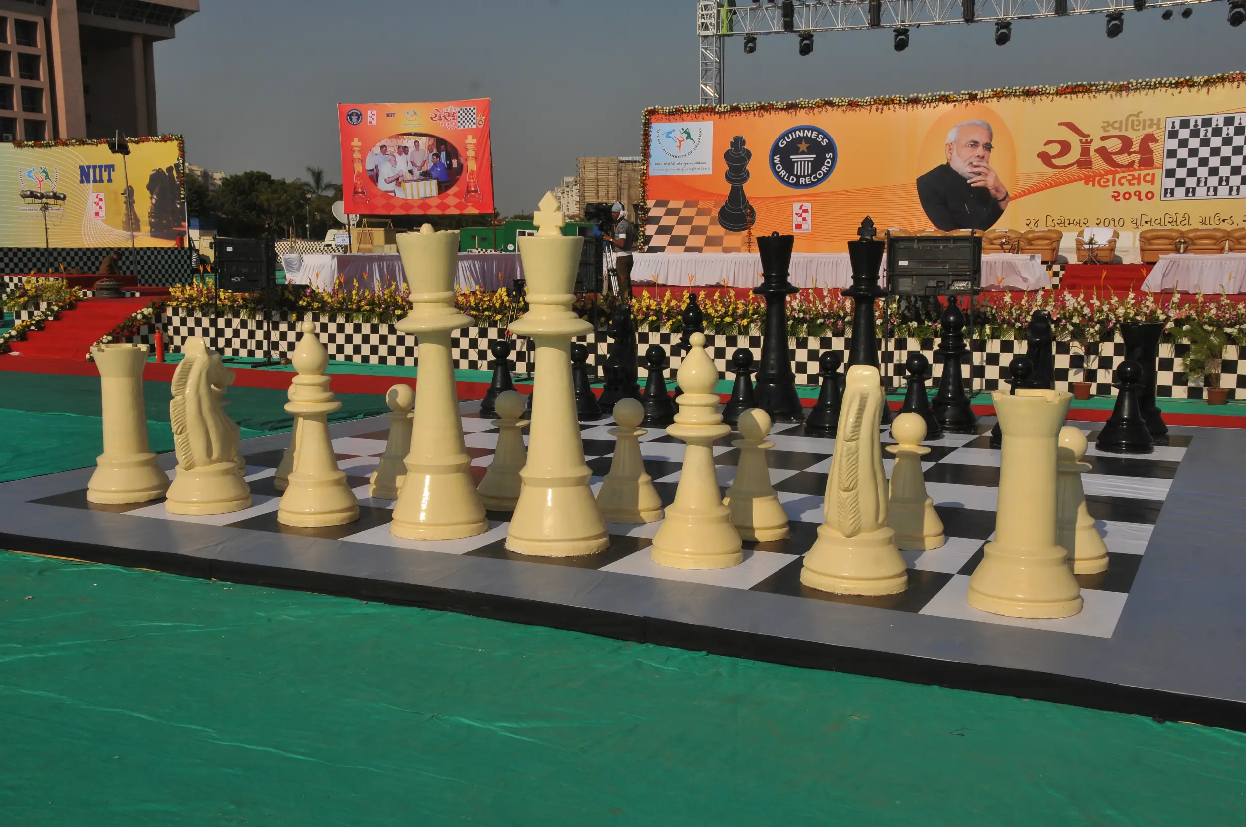 Men lighting ceremonial lamp at event with ITT banner in background